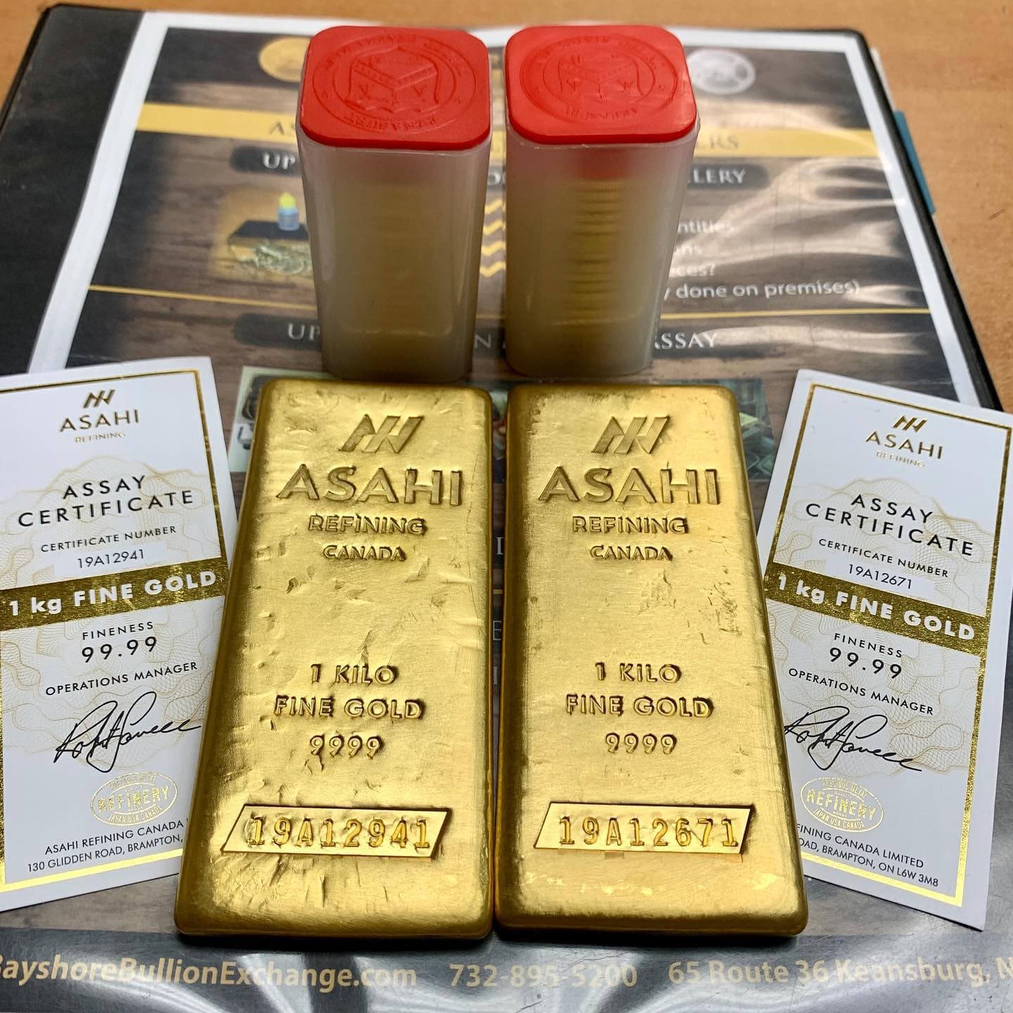 Two 1-kilo Asahi Refining fine gold bars with assay certificates.